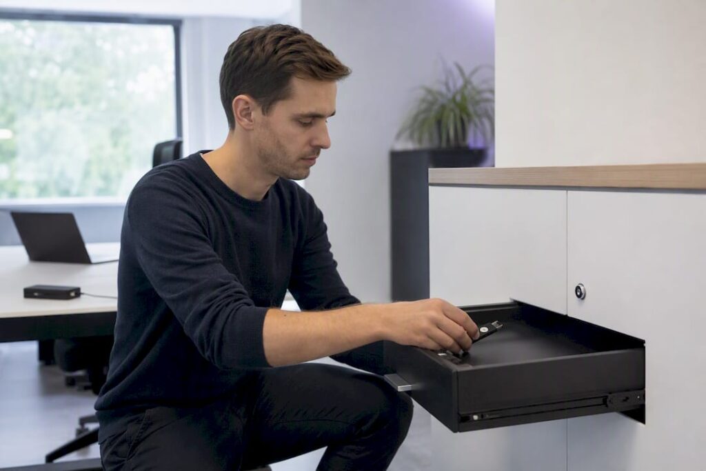 Hände legen ein Hardware-Sicherheitsmodul in einen verschlossenen Schrank.