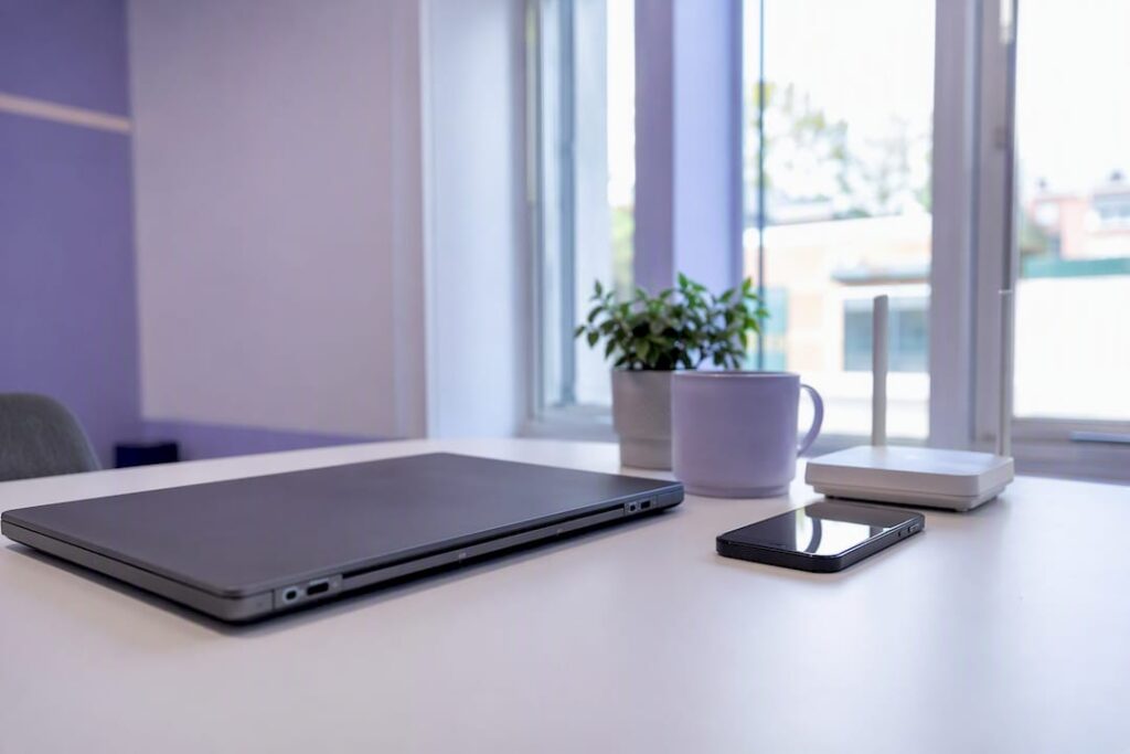Laptop und Smartphone auf dem Schreibtisch eines KMU